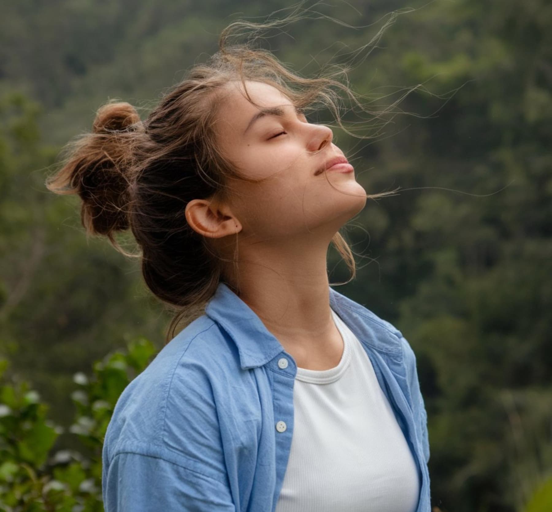 Femme respirant en pleine nature : Respiration consciente et oxygénation naturelle au cœur de la forêt.