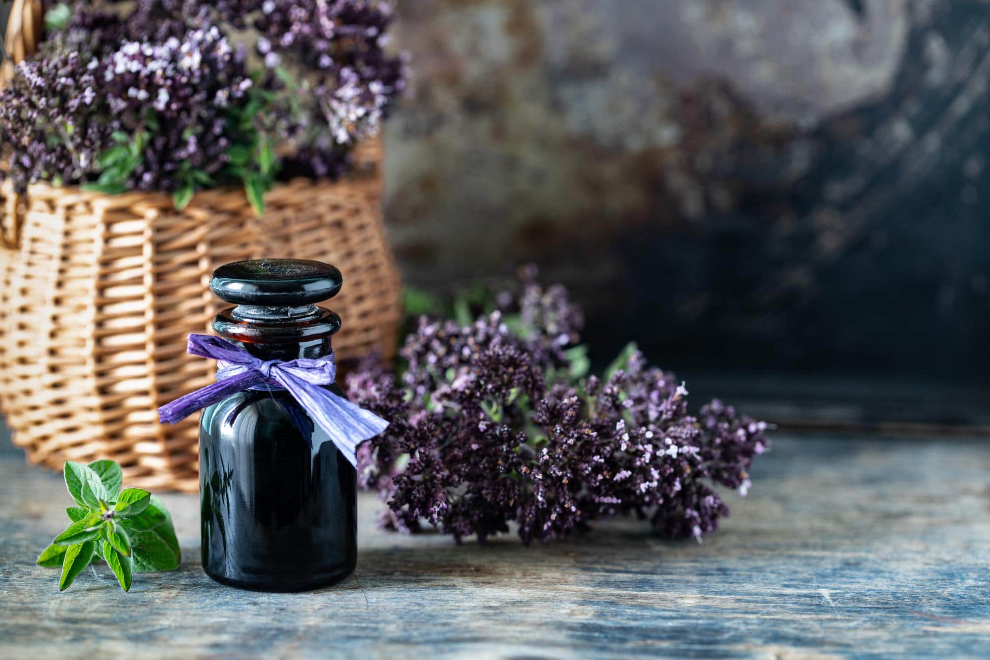 Flacon d'huile essentielle de lavande vraie entouré de fleurs de lavande, traditionnellement utilisée pour favoriser la relaxation.