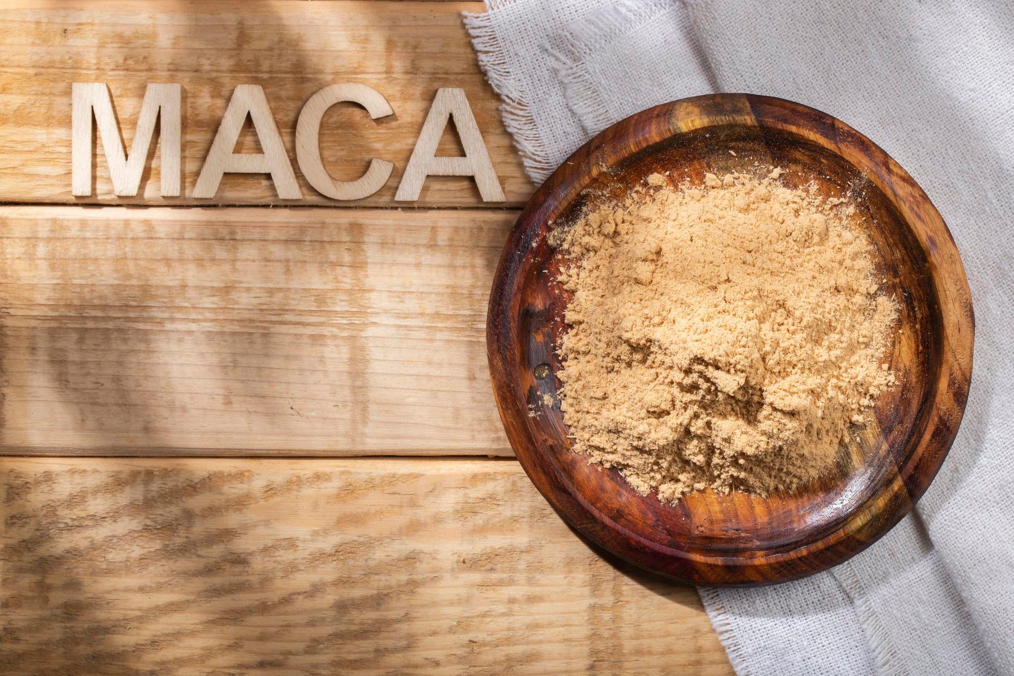 Bol de poudre de maca posé sur une table en bois, utilisé traditionnellement pour soutenir la vitalité et le bien-être.