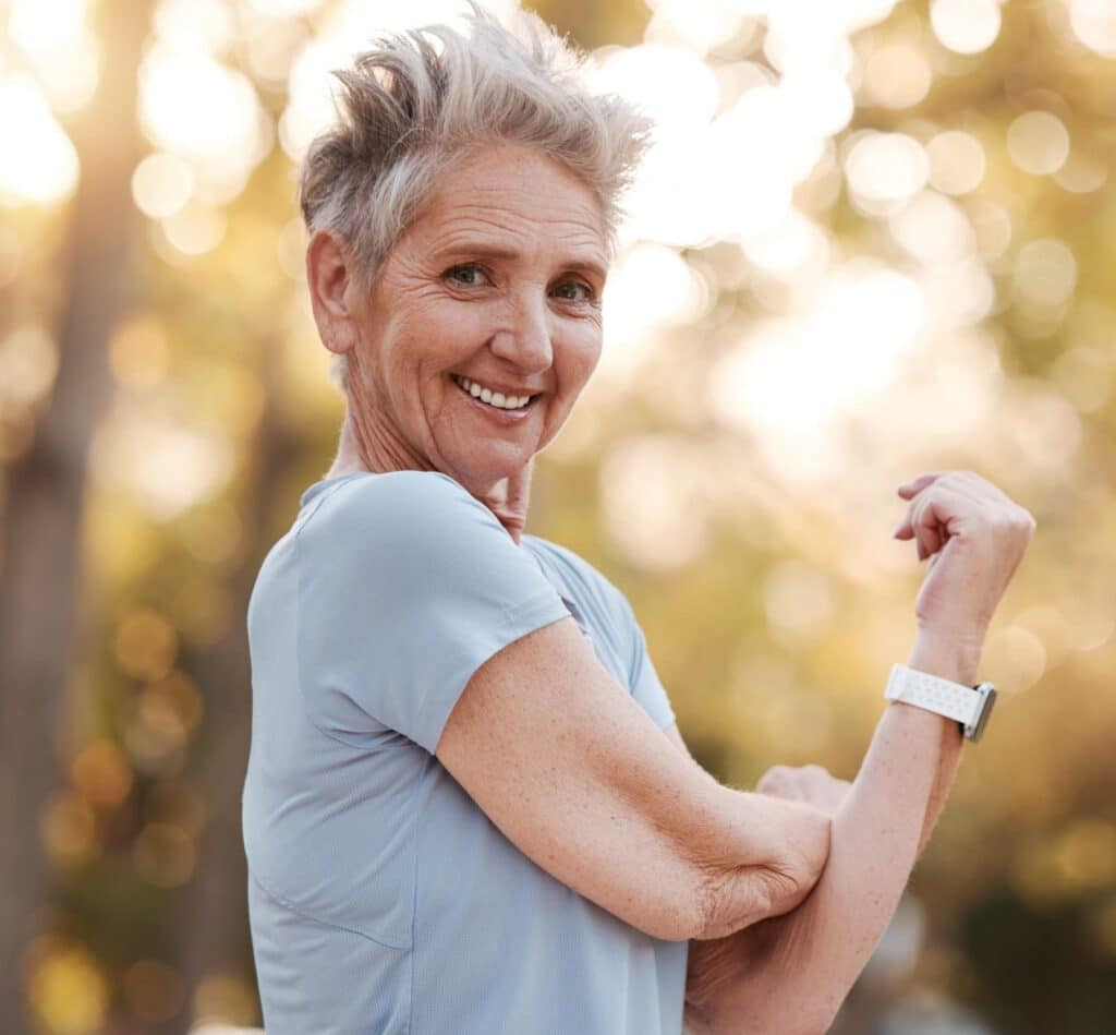 Femme souriante réalisant un exercice de mobilité des bras pour préserver naturellement la souplesse et le confort de ses articulations.