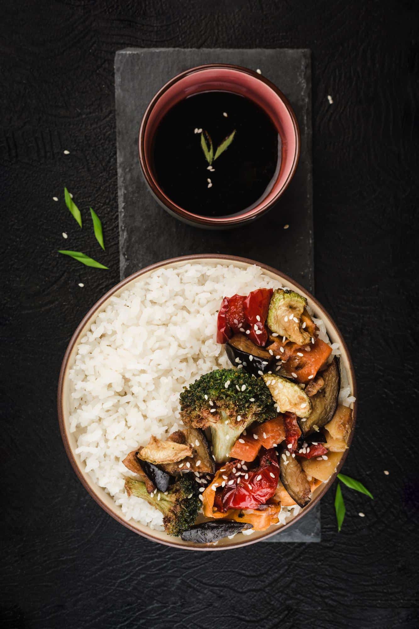 Bowl de riz accompagné de légumes rôtis, servi avec une sauce soja dans le cadre d'un repas de batch cooking.