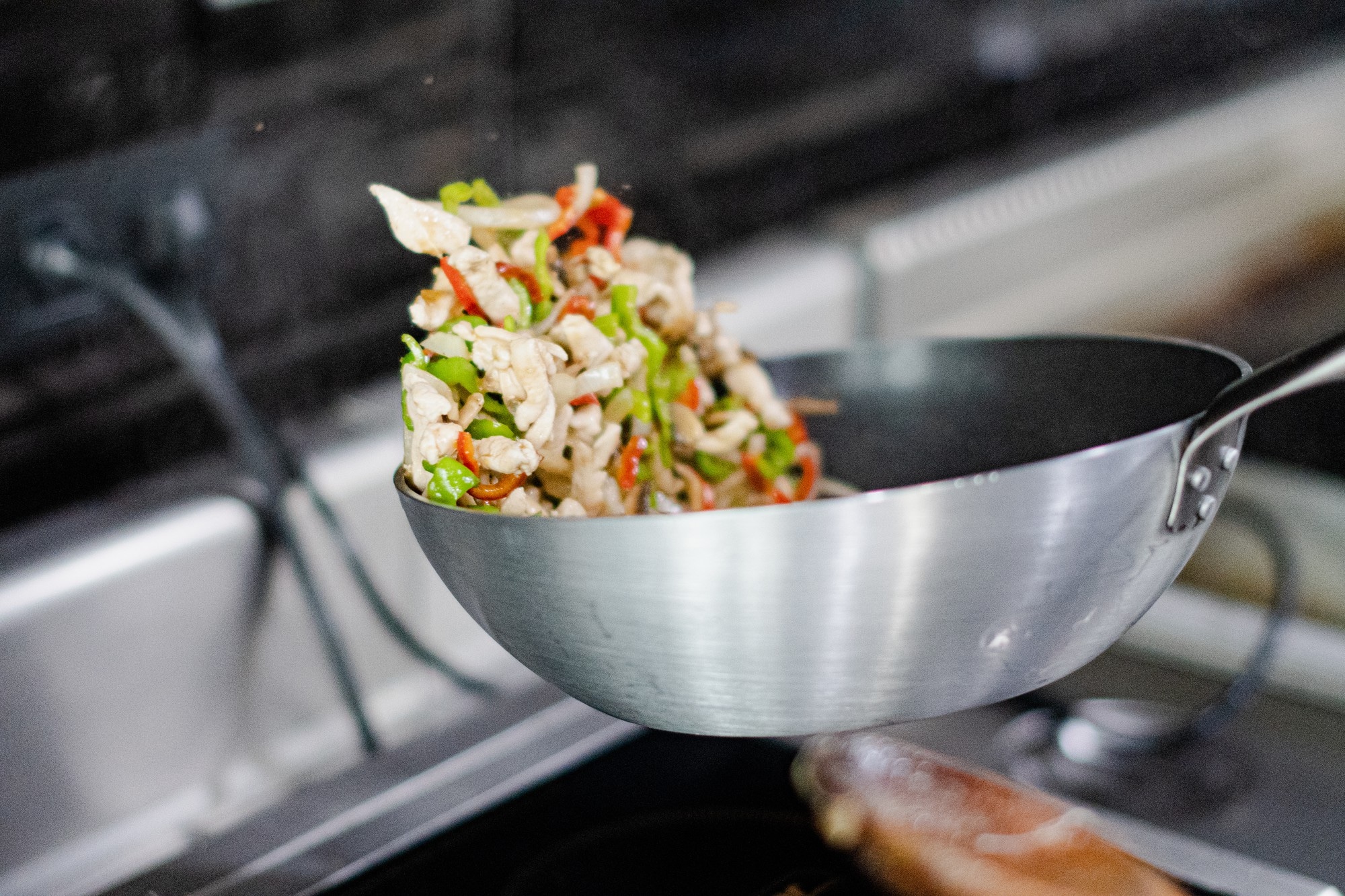 Wok en inox contenant un mélange de légumes et de protéines en cuisson, idéal pour préparer plusieurs repas en batch cooking.