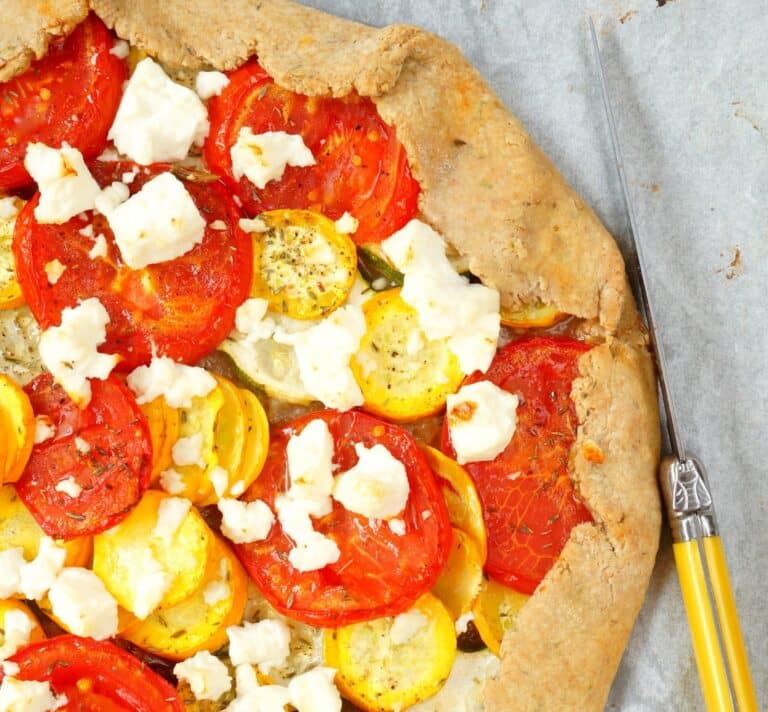 Tarte rustique aux tomates rouges et courgettes jaunes, garnie de feta émiettée sur pâte au petit épeautre – recette végétarienne estivale