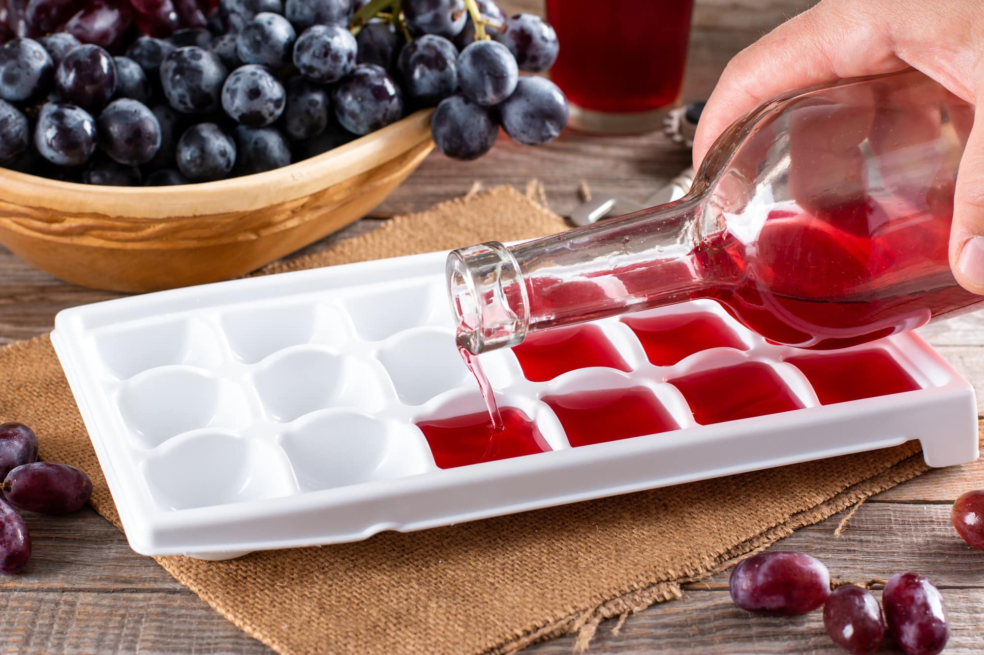 Préparation de glaçons à base d'infusion de vigne rouge pour soulager naturellement les jambes lourdes en été.