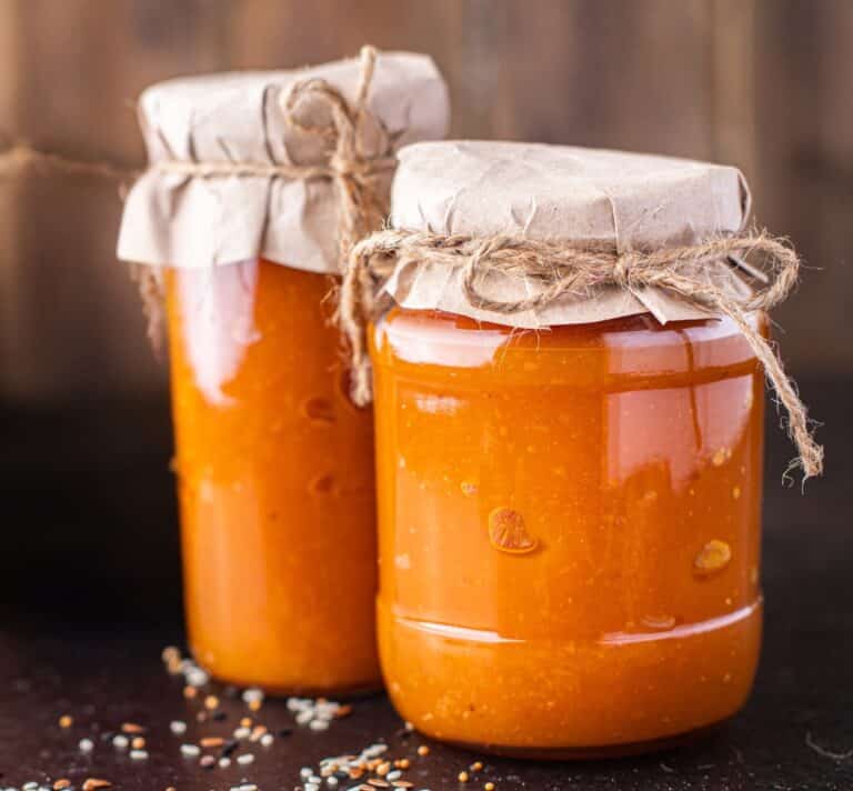 Pots de confiture de carottes aux épices douces faits maison, couverts de papier kraft et ficelle naturelle