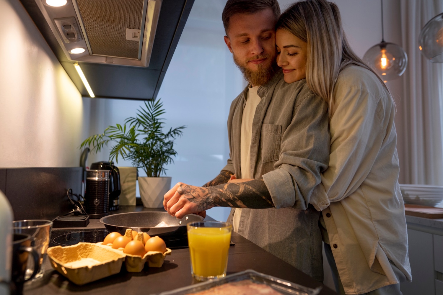 Un couple cuisine ensemble dans une ambiance chaleureuse, illustrant une cuisine d’hiver réconfortante, simple et conviviale.