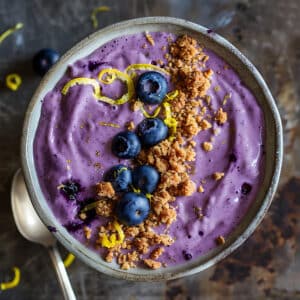 Smoothie bowl violet riche en anthocyanes avec myrtilles et granola