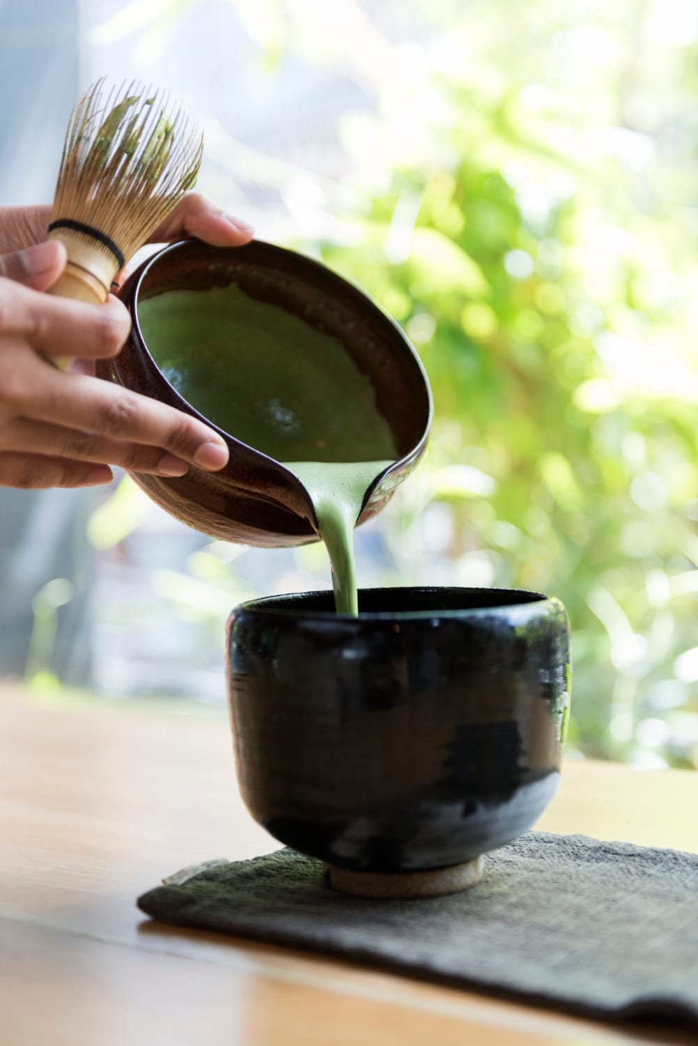 Thé matcha japonais versé dans un bol lors de sa préparation traditionnelle