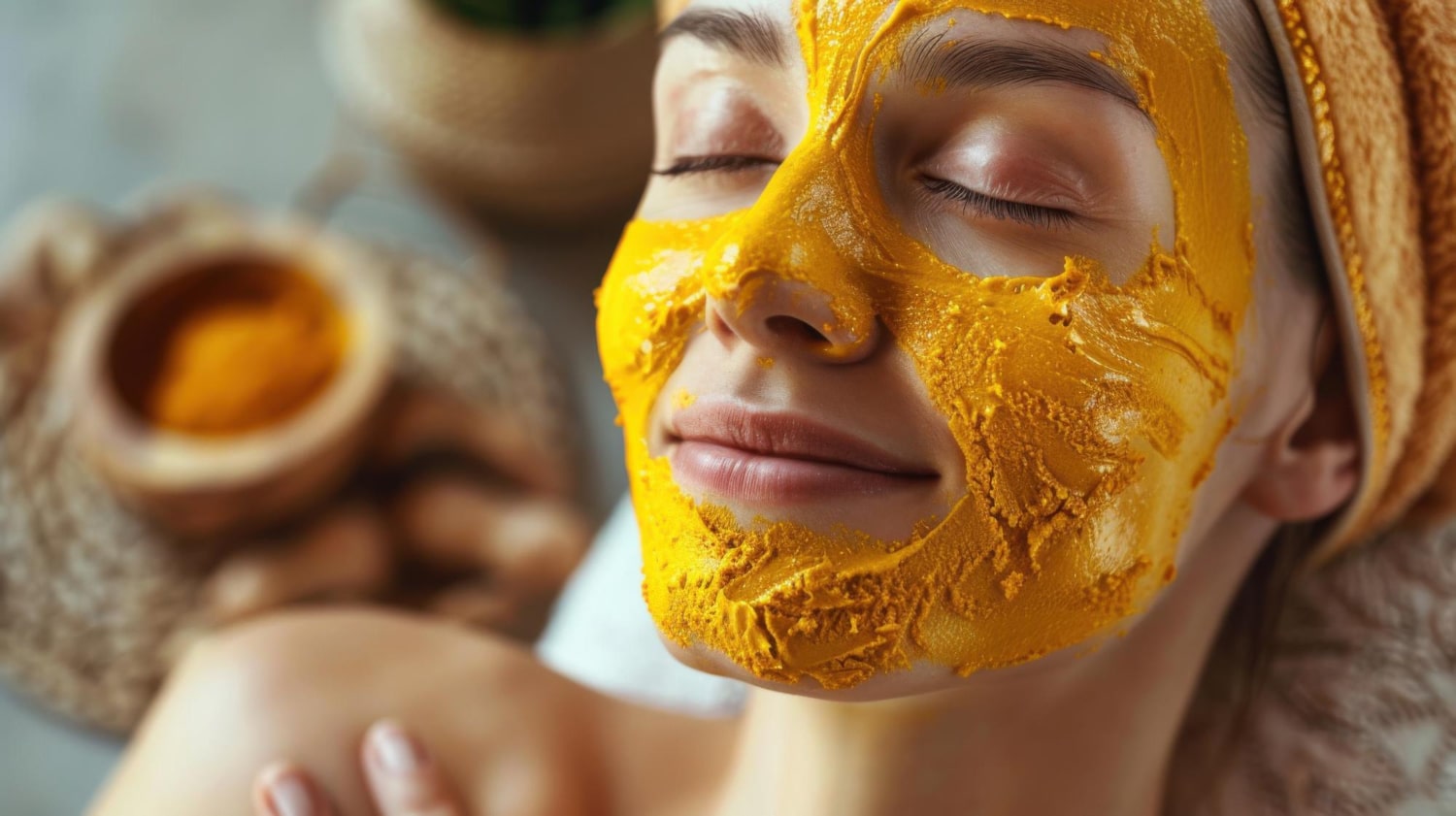 femme appliquant un masque visage au curcuma, usage cosmétique du curcuma pour illuminer la peau