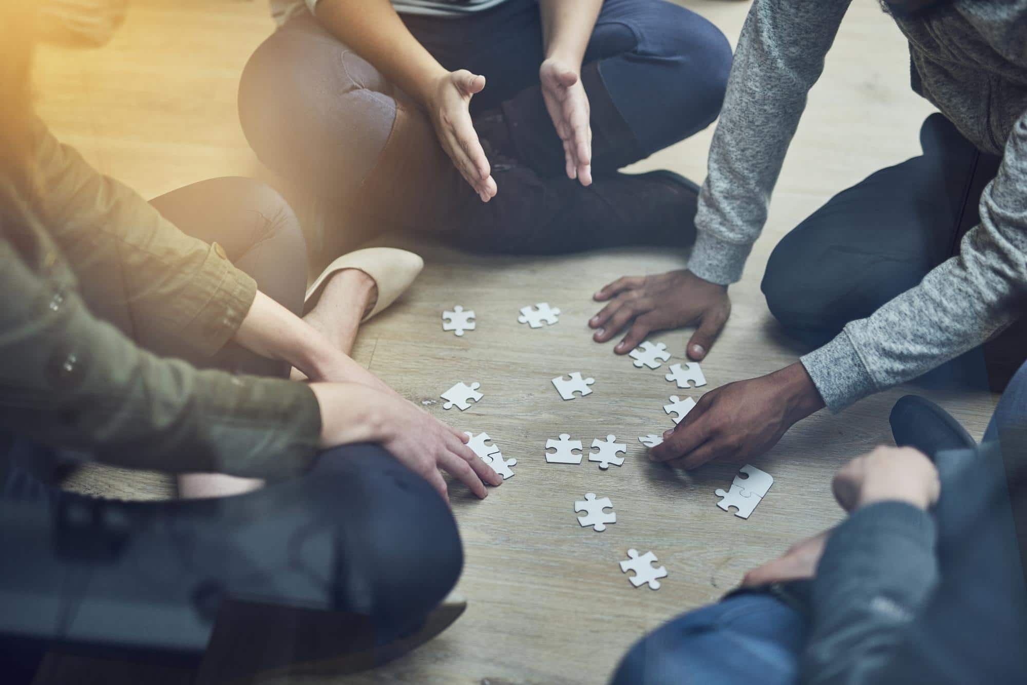 Groupe de personnes réunies autour d’un puzzle, illustrant la coopération et la solidarité territoriale face aux enjeux climatiques
