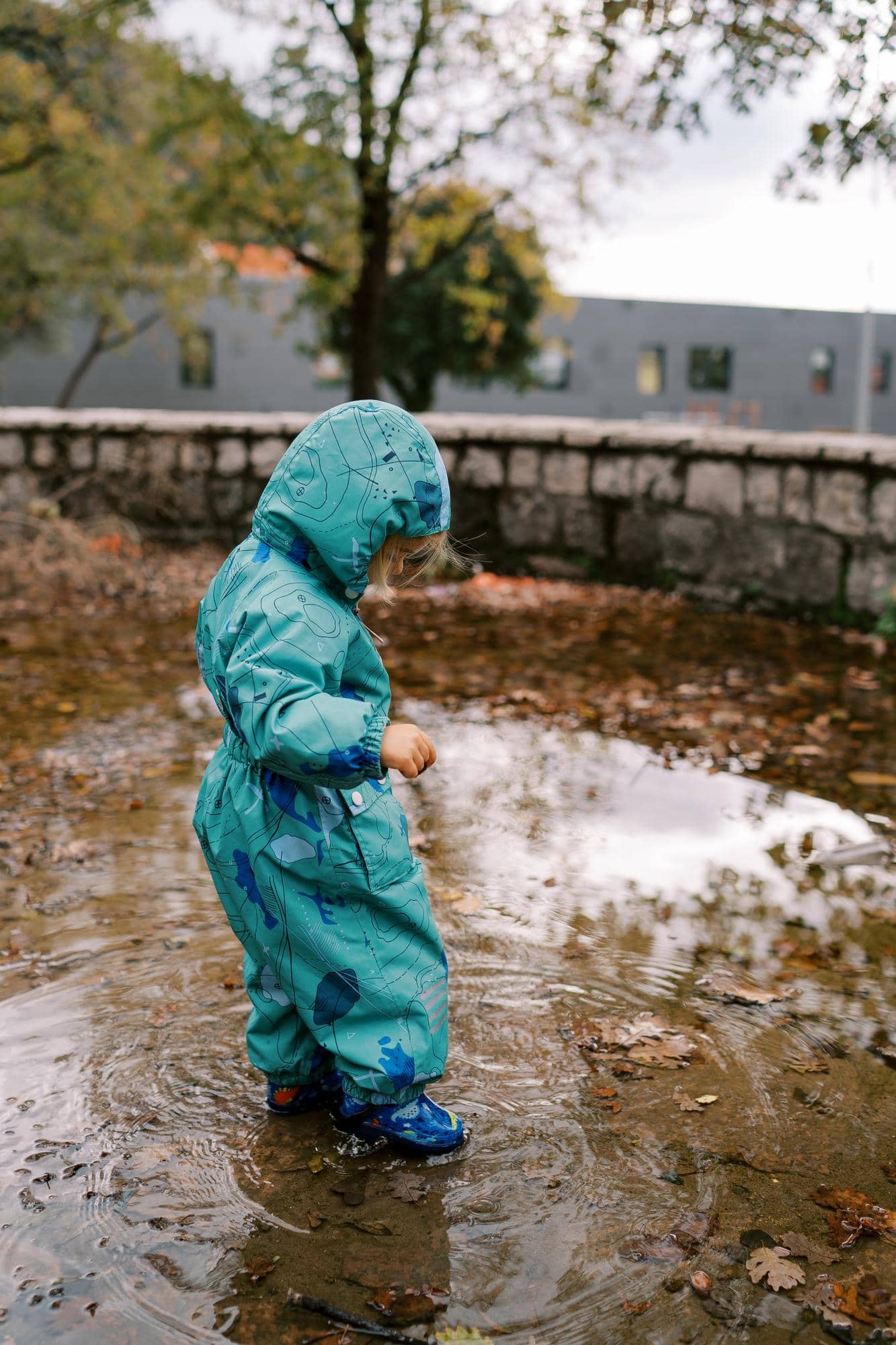 Enfant équipé de bottes marchant dans une flaque d’eau, symbole de la nécessité de protéger les territoires face aux inondations