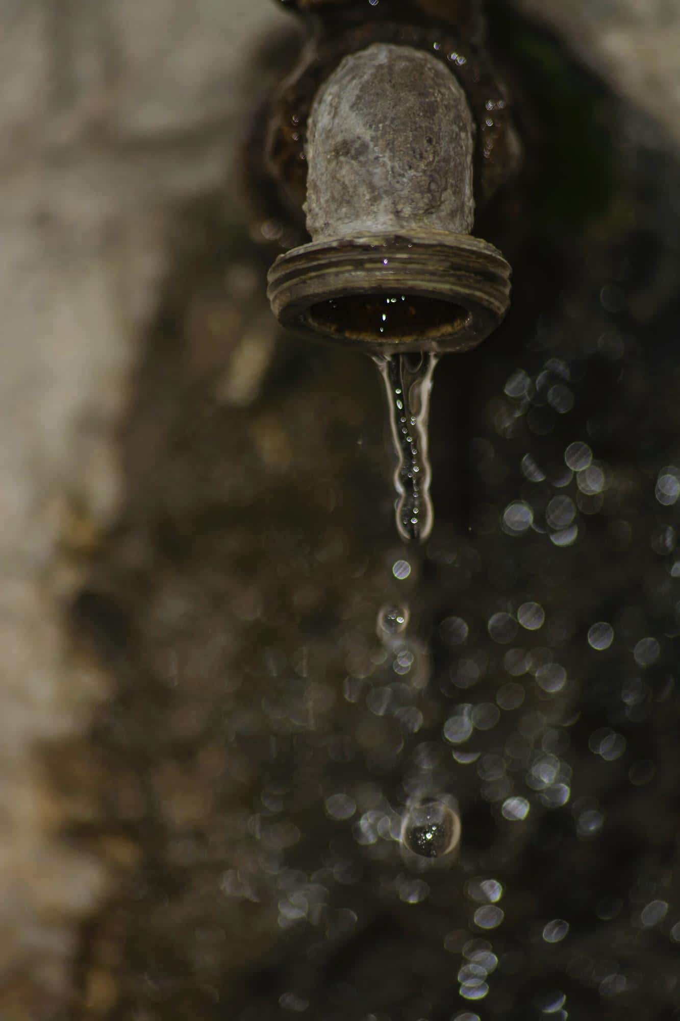 Robinet laissant couler de l’eau, symbole du gaspillage et de l’épuisement des ressources en eau potable
