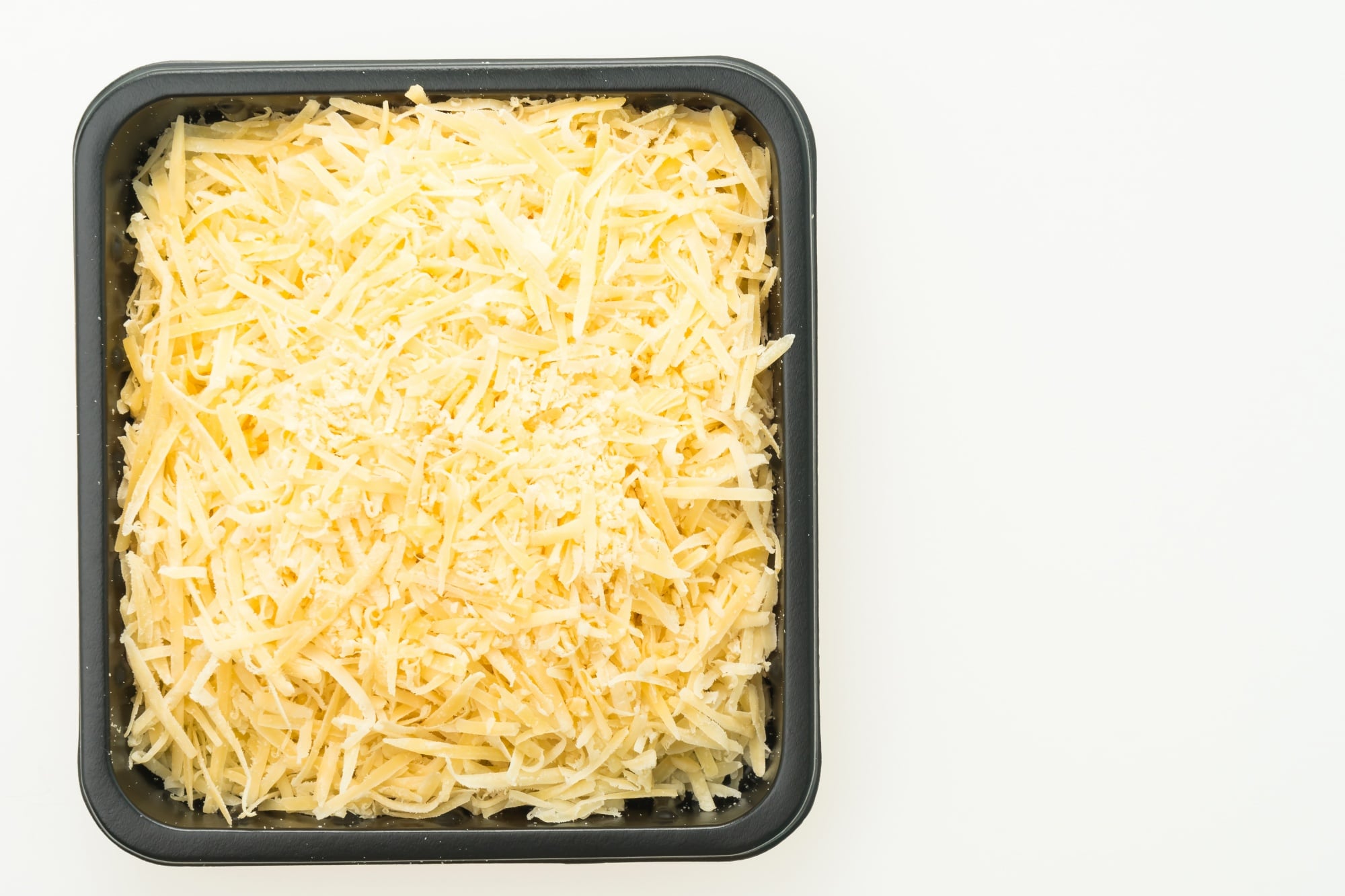 Barquette de fromage râpé, montrant un produit transformé contenant des agents anti-agglomérants