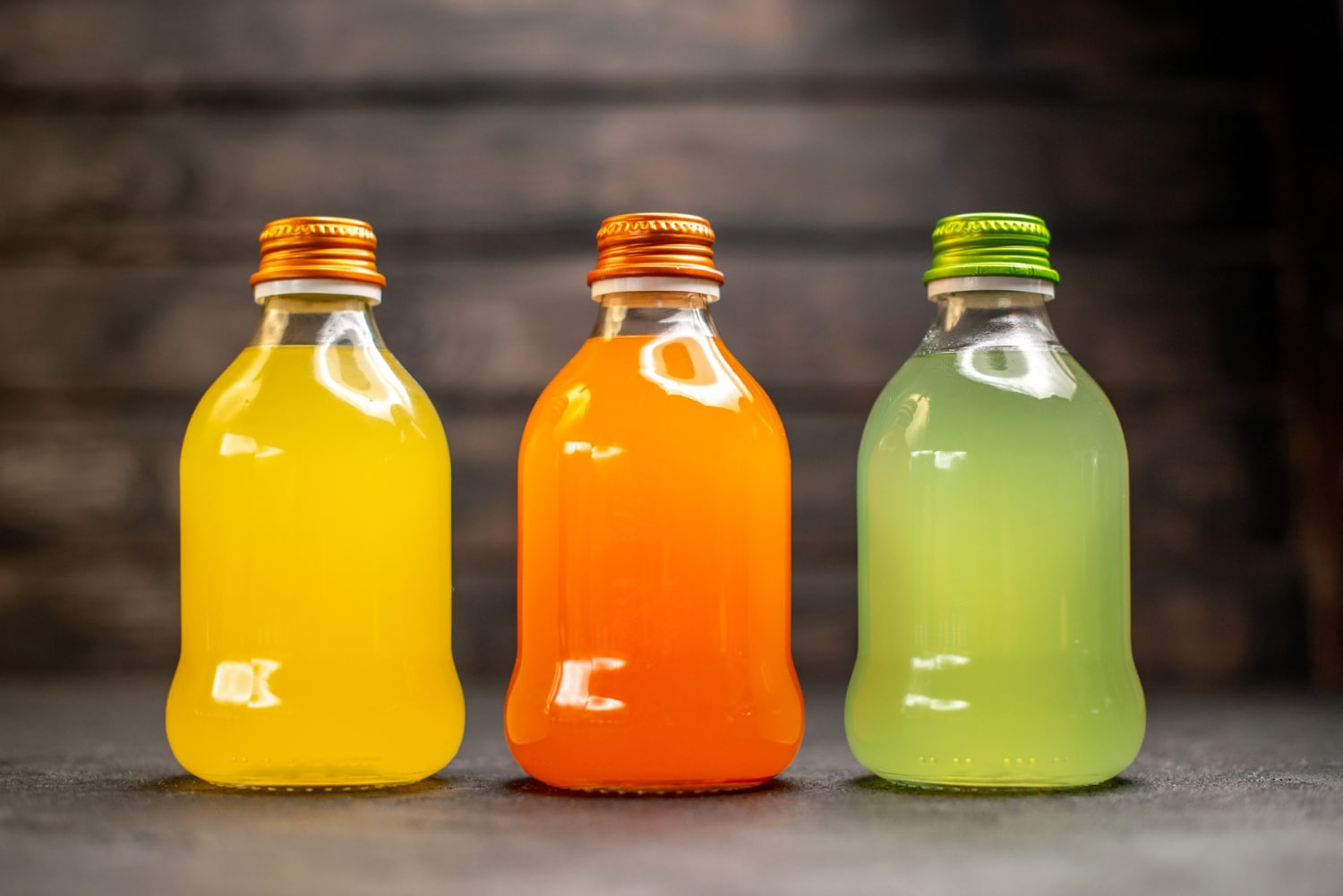 Bouteilles de jus de fruits colorés, illustrant des jus reconstitués ou standardisés