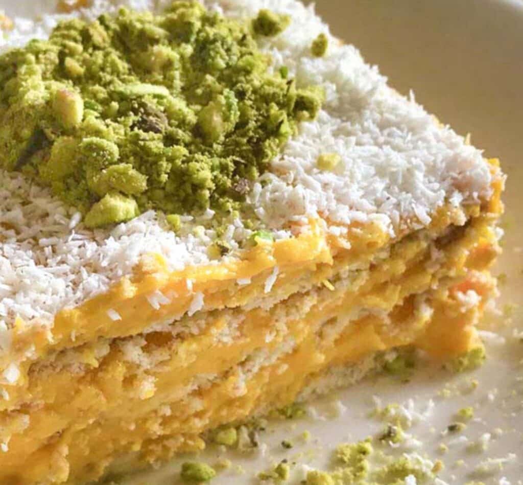 Gâteau aux carottes vegan décoré de noix de coco râpée et pistaches