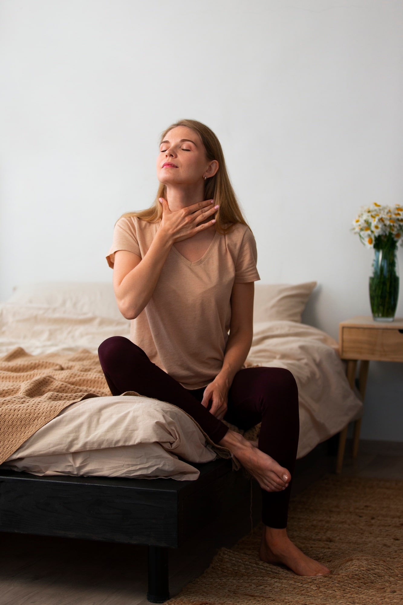 Femme assise calmement pratiquant une respiration apaisante chez elle
