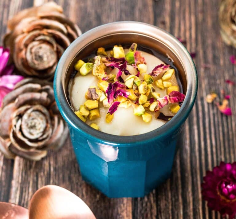Crème dessert iranienne ferni avec pistaches concassées et pétales de rose dans un ramequin