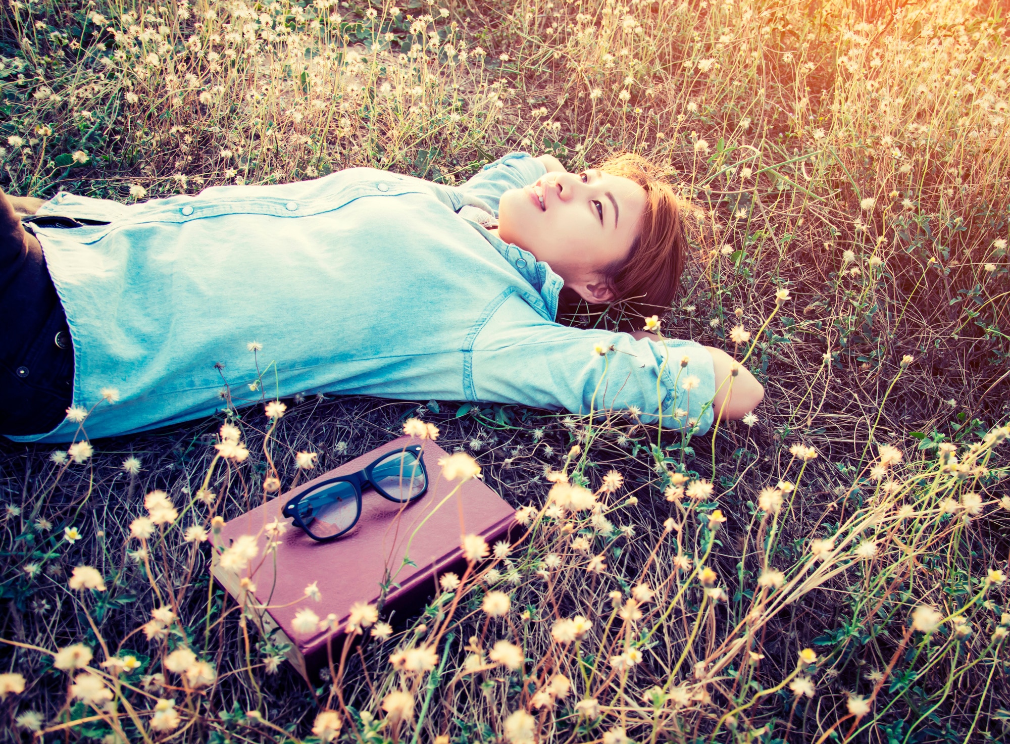 Jeune femme allongée dans l’herbe profitant d’un moment de détente
