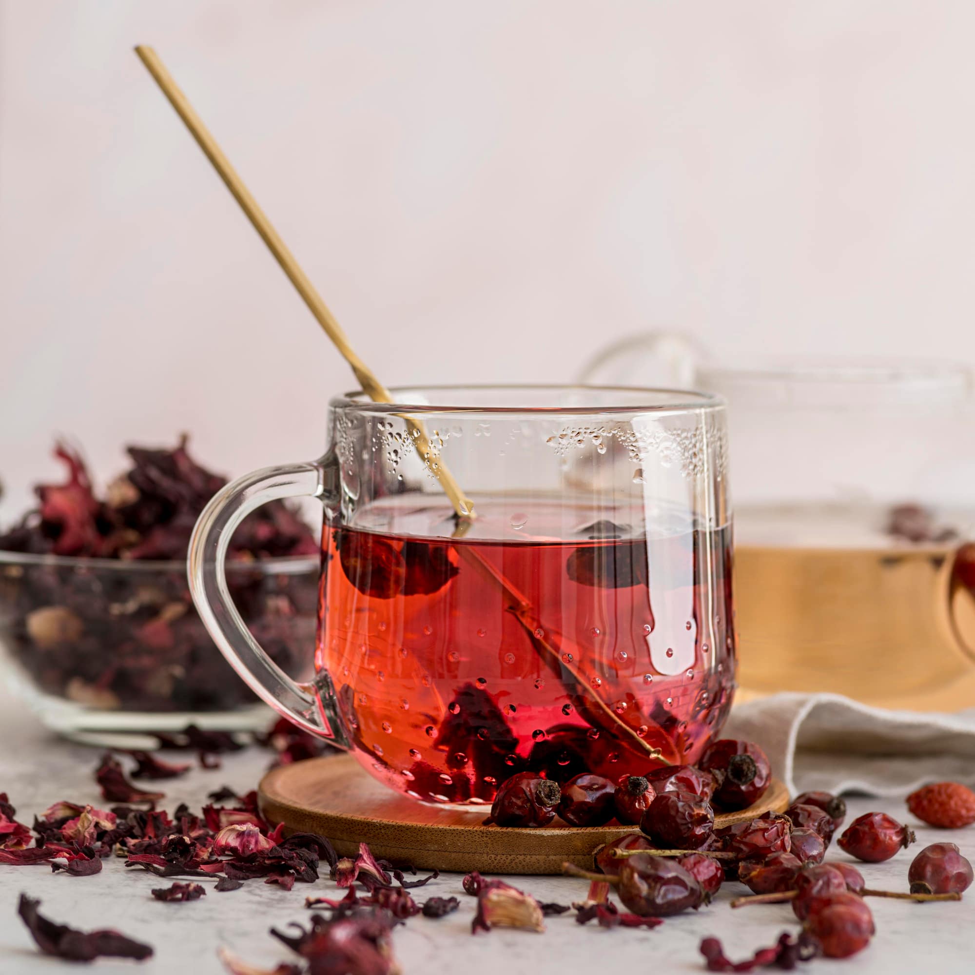 Infusion rouge aux baies de goji et fruits rouges servie dans une tasse en verre, boisson naturelle riche en saveurs et idéale pour une pause bien-être