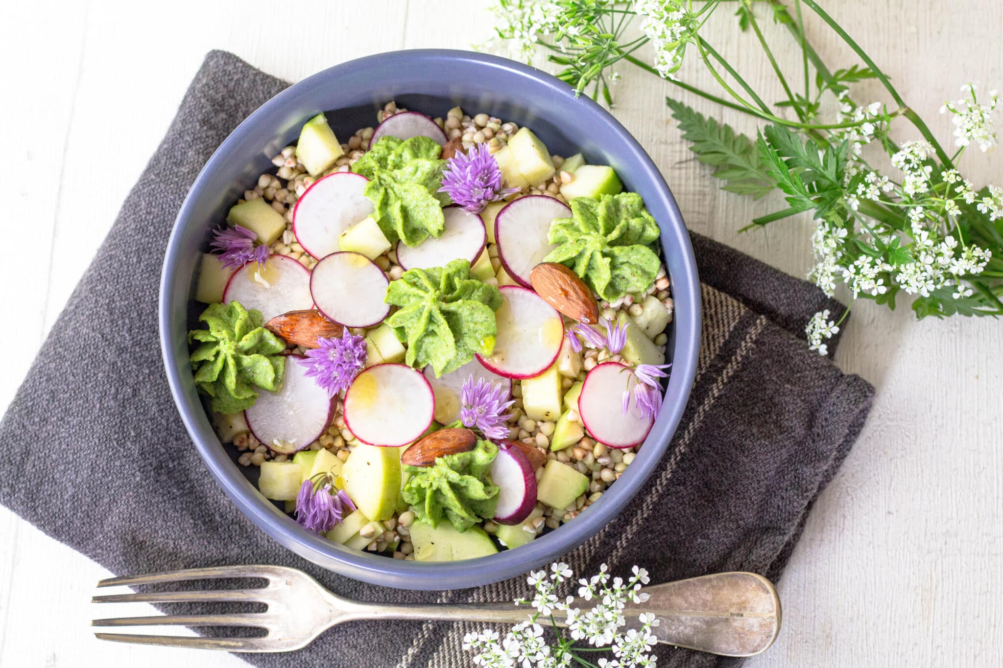 Salade de sarrasin avec radis, courgette et pesto de fanes de radis présentée en bol