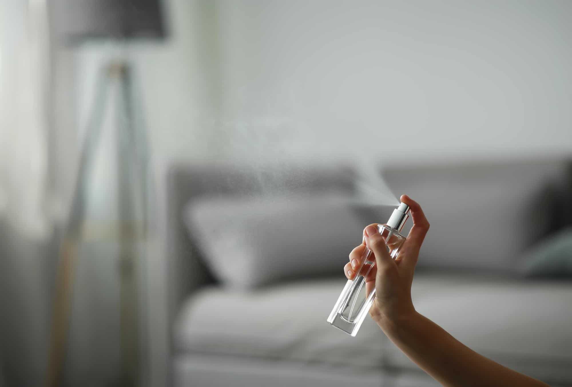 Main pulvérisant une brume végétale maison dans un intérieur lumineux pour apporter fraîcheur et confort pendant les fortes chaleurs.