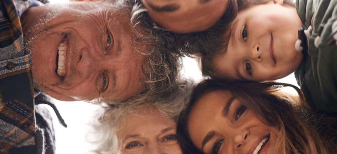 Famille réunie souriante représentant les liens entre générations pour la fête des pères