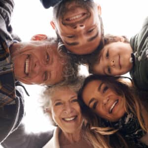 Famille réunie souriante représentant les liens entre générations pour la fête des pères