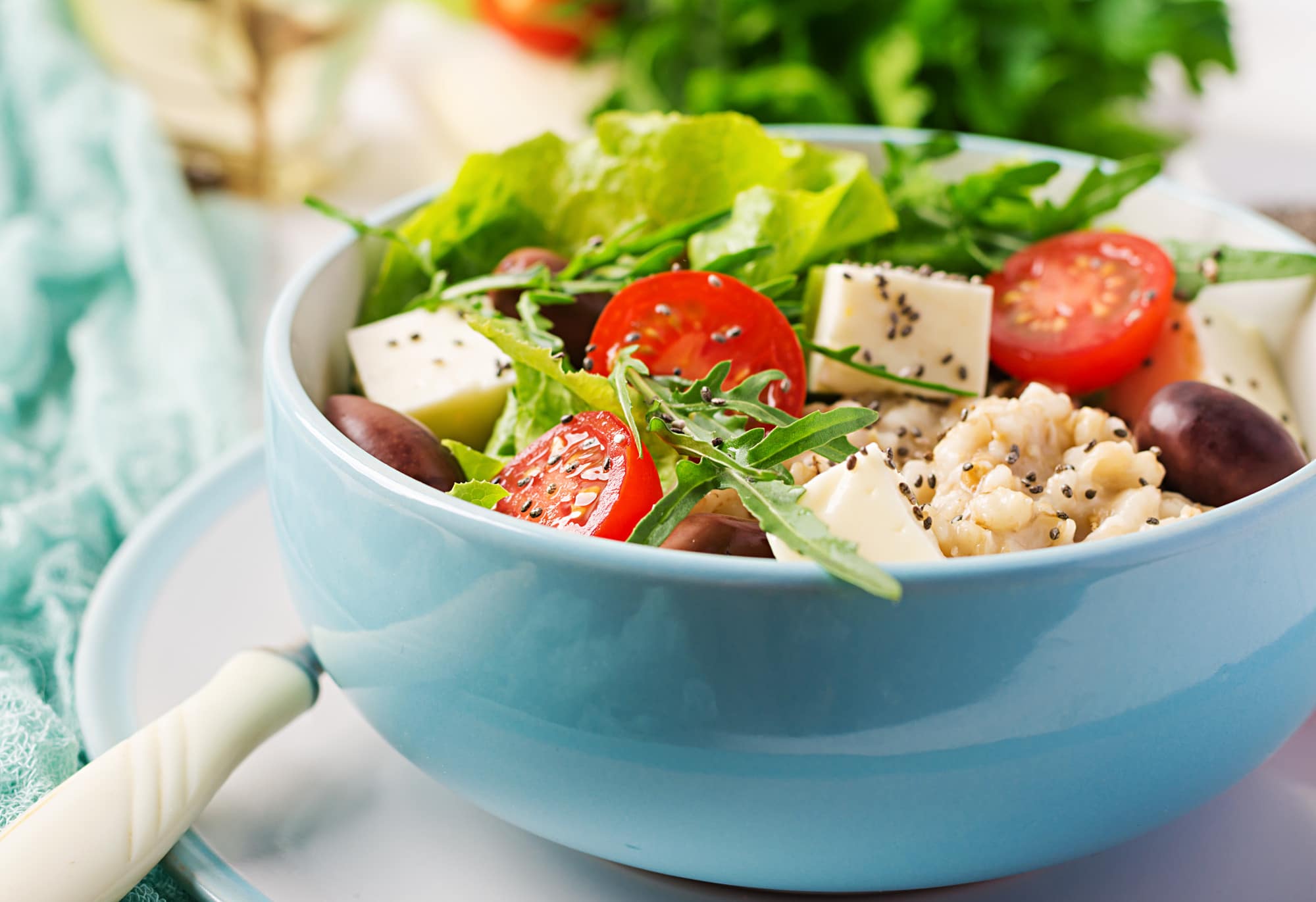 Salade composée avec dés d'alternative végétale au fromage, tomates cerises, olives et jeunes pousses.