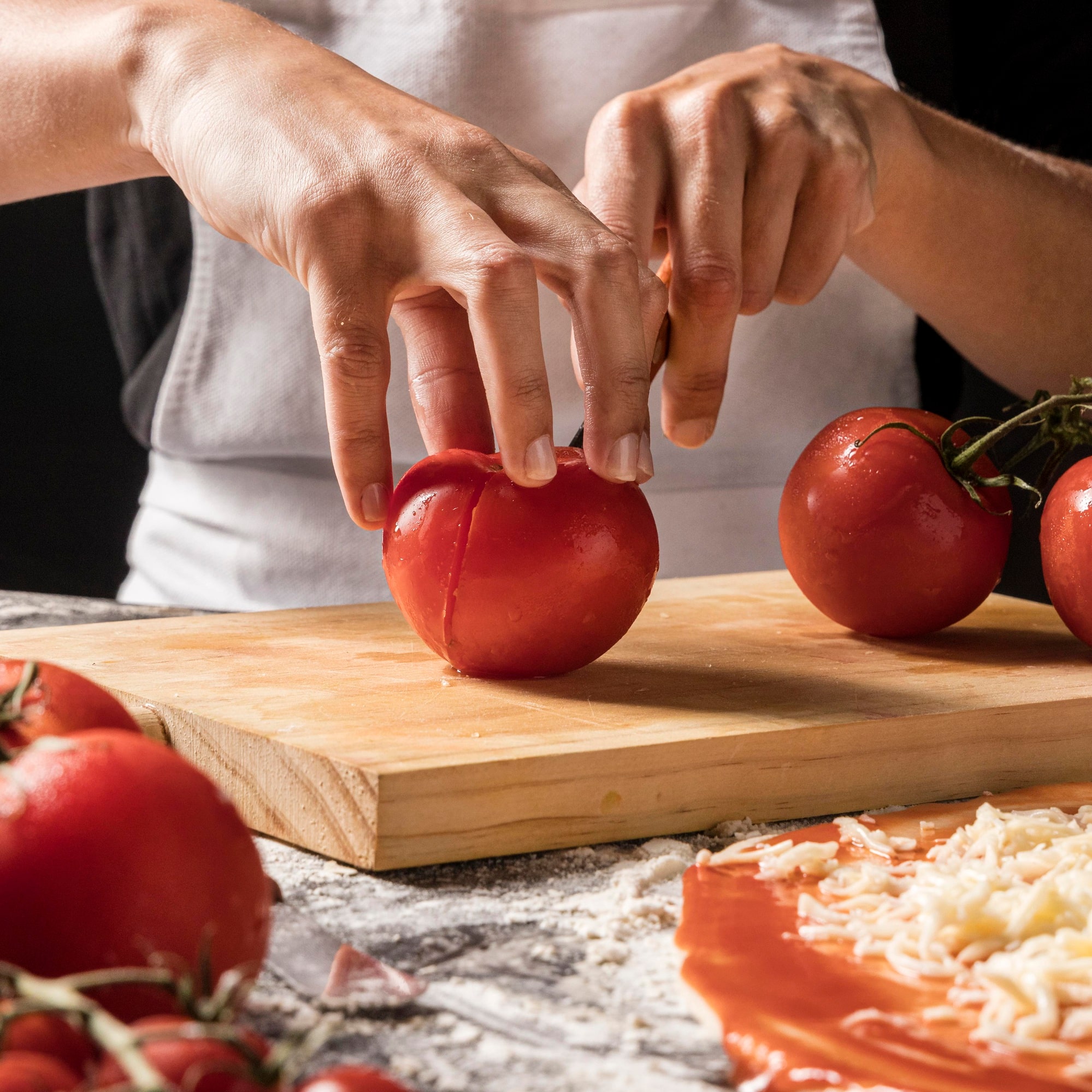 Préparation des tomates avant de les garnir de fromage frais, de bleu et de basilic.