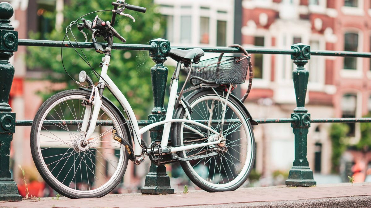Vélo attaché sur un pont urbain, symbole des aménagements cyclables en ville et de la pratique du vélo en milieu urbain et rural.